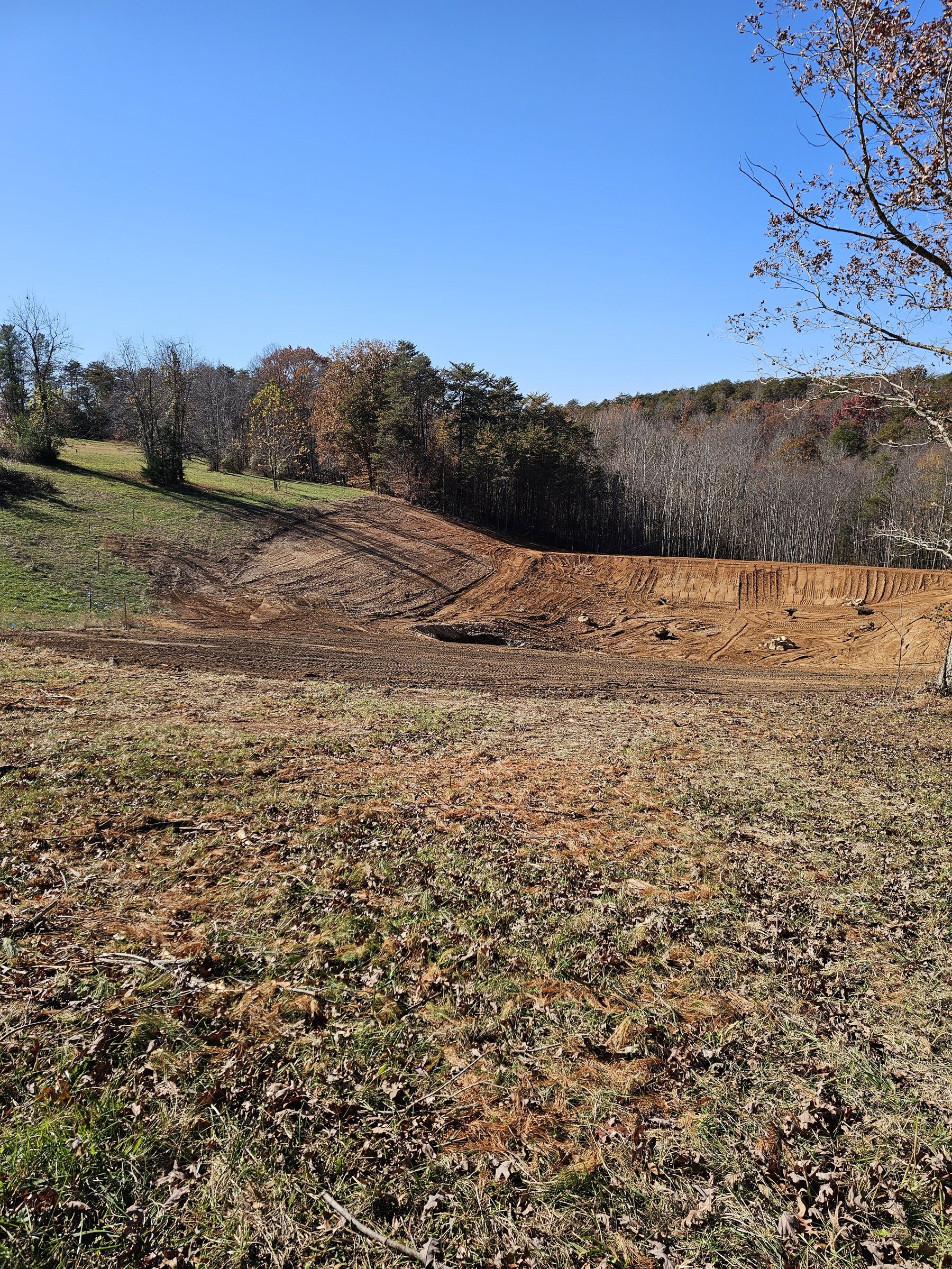 After pond construction: Completed custom fishing pond with clear water in Stokes County, NC